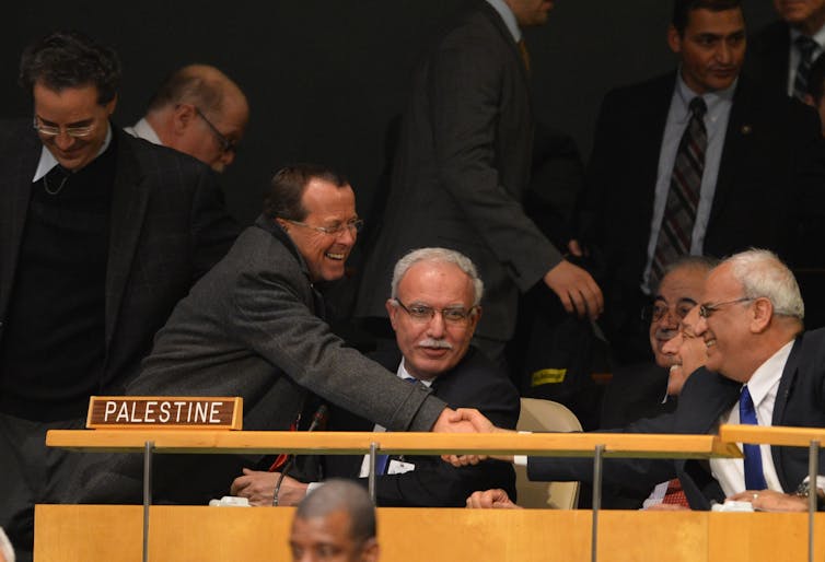 Two men shake hands.